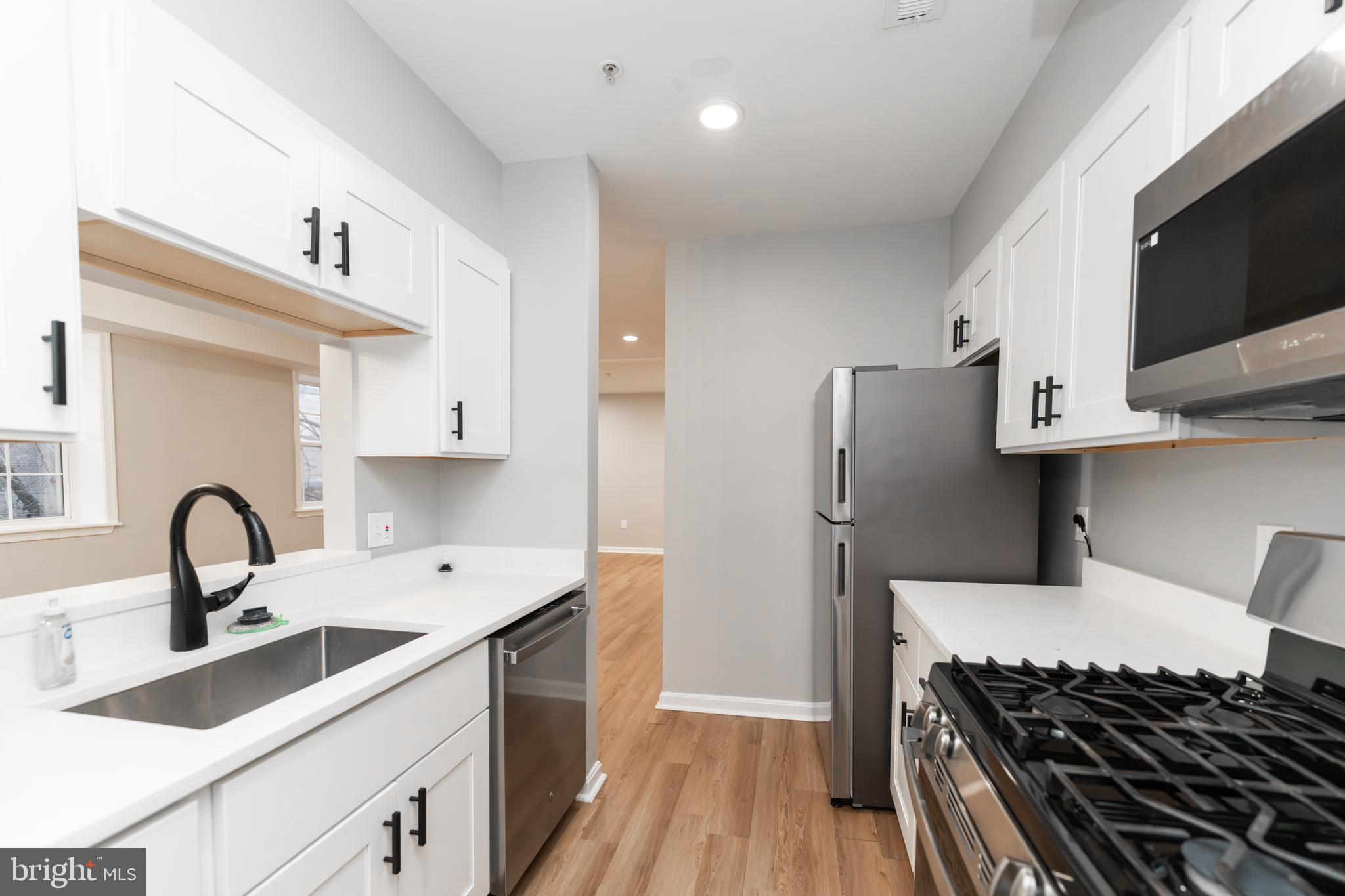 1008 Rittenhouse Street Northwest, Unit 15 Washington, DC 20011 - Photo 10 of 28 a kitchen with a sink stove and refrigerator