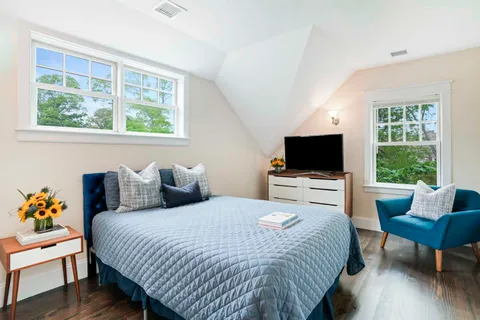 a bedroom with a bed a couch and a flat screen tv