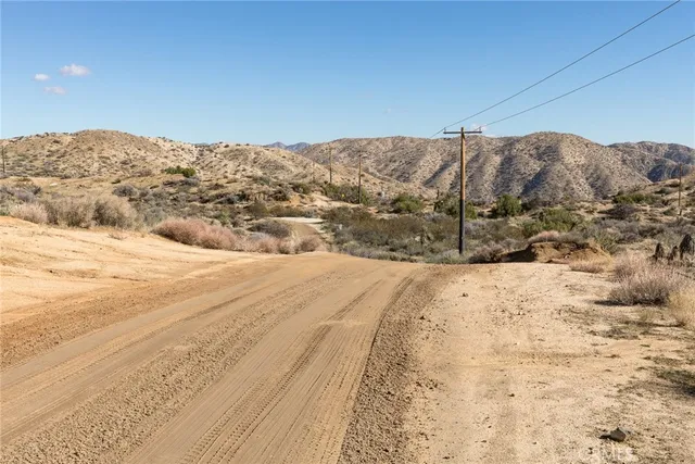a view of a dry yard covered with snow in the background