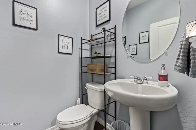 a bathroom with a sink mirror and toilet