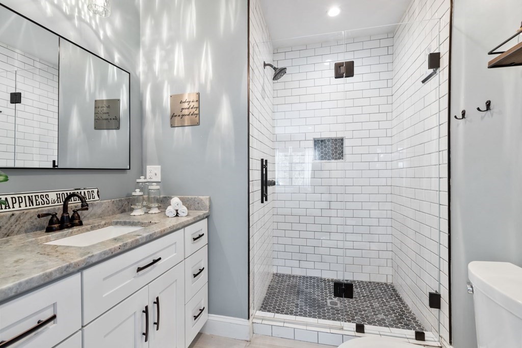 36 Eaton Road Framingham, MA 01701 - Photo 20 of 33 a bathroom with a granite countertop sink a toilet a mirror and shower