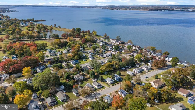 a view of a white house with a big yard and large trees