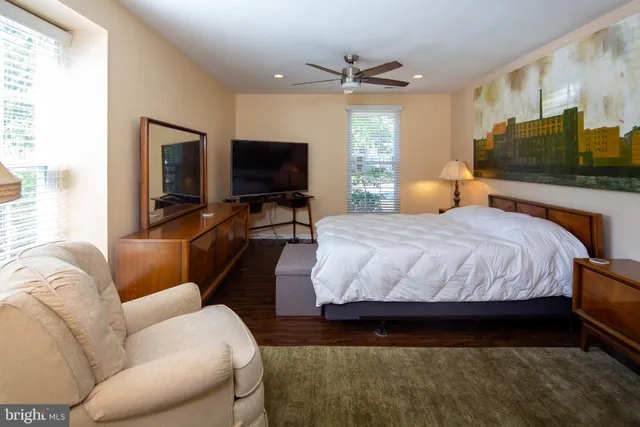 a bedroom with a bed a couch and a flat screen tv