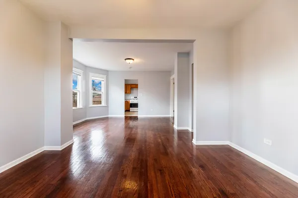 a view of empty room with wooden floor