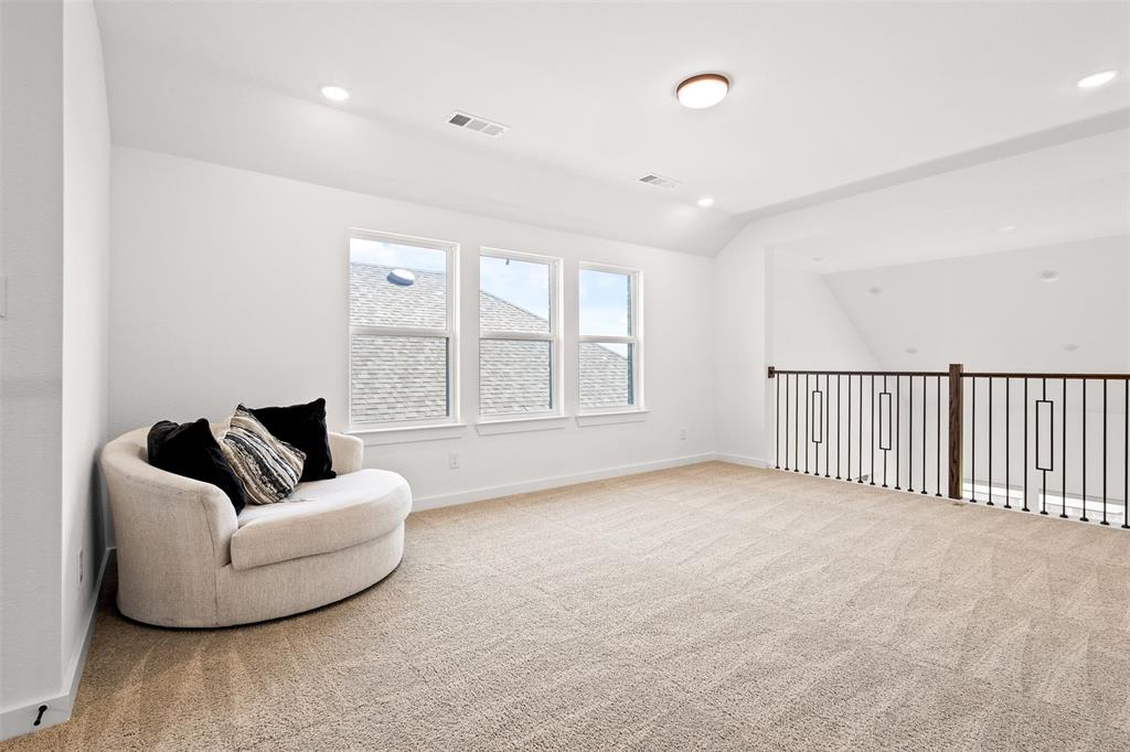 1825 Rough Rdg Trail Midlothian, TX 76065 - Photo 16 of 37 Expansive carpeted room featuring a white color palette, a trio of windows, overhead recessed lighting, and a dark metal and wood-finish railing
