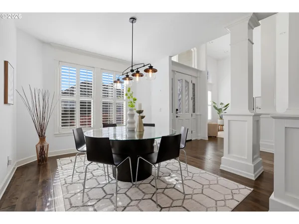 a view of a dining room and livingroom with furniture wooden floor a chandelier