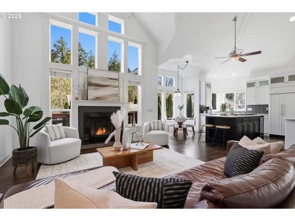 a living room with furniture fireplace and a large window