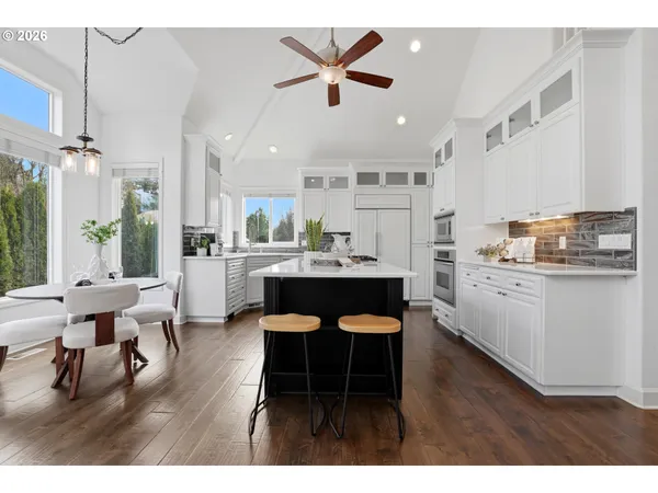 a kitchen with a dining table chairs and white appliances