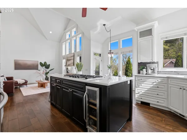a kitchen with kitchen island granite countertop a sink cabinets and wooden floor