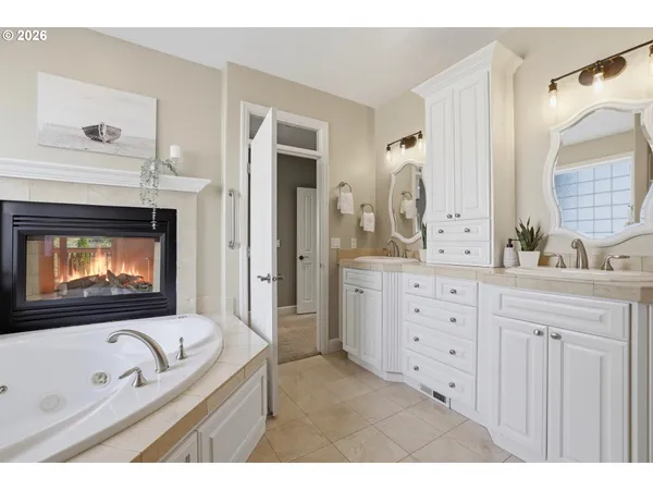 a en suite bathroom with a granite countertop tub sink and mirror