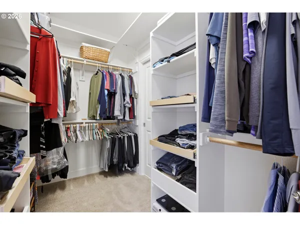 a view of walk in closet with clothes and shoes