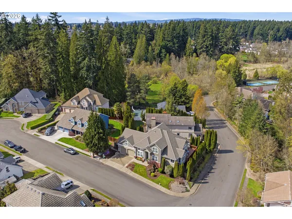 an aerial view of a house with a garden and lake view