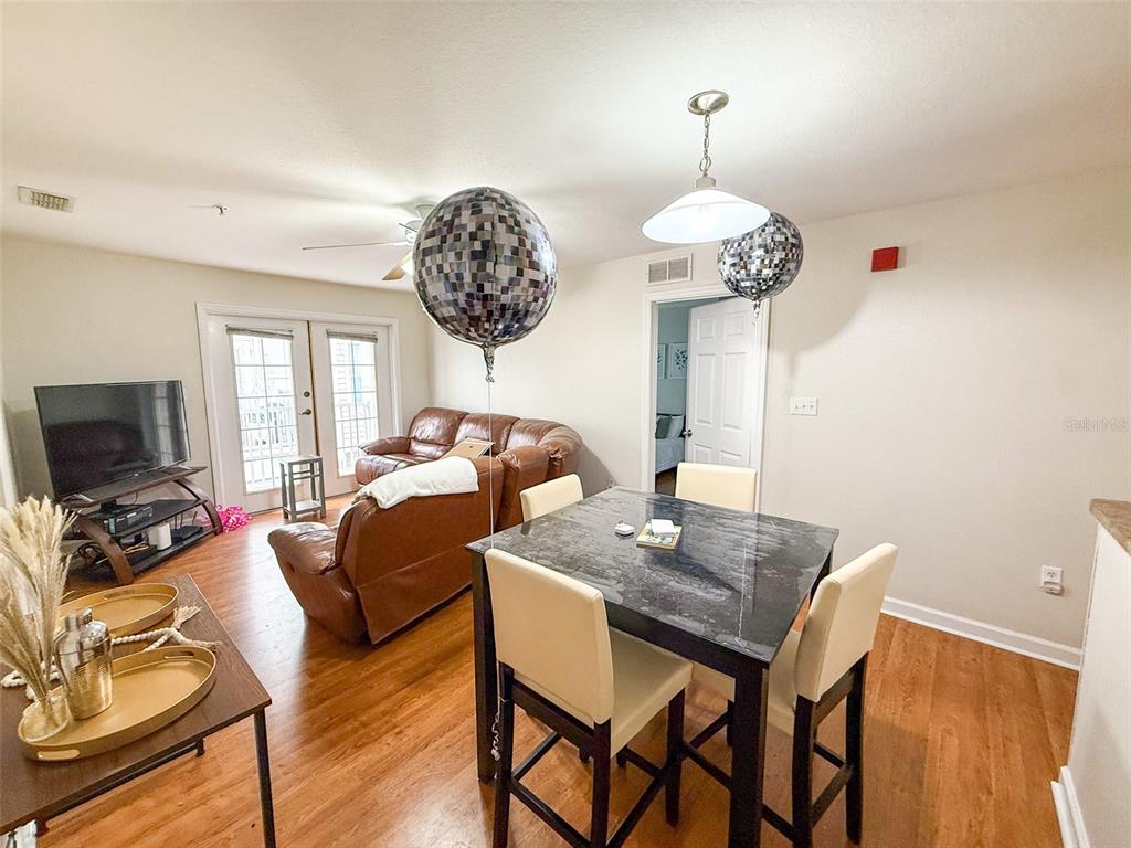 835 Southwest 9th Street, Unit 108 Gainesville, FL 32601 - Photo 4 of 9 a view of a dining room with furniture a chandelier and wooden floor