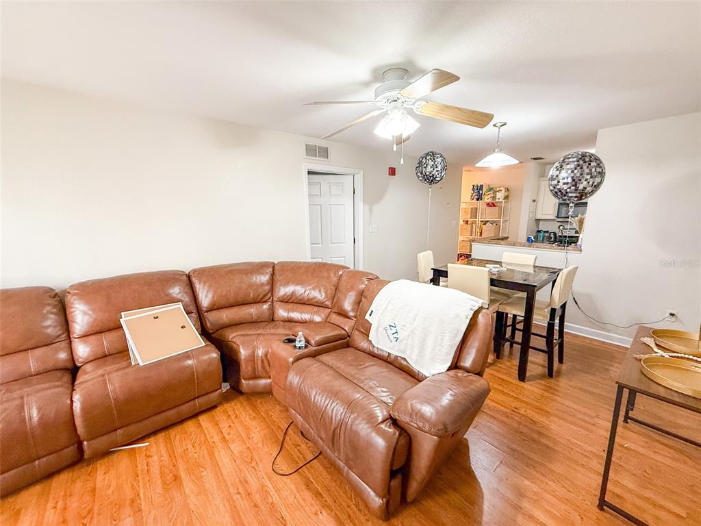 835 Southwest 9th Street, Unit 108 Gainesville, FL 32601 - Photo 8 of 9 a living room with a bed and a chandelier