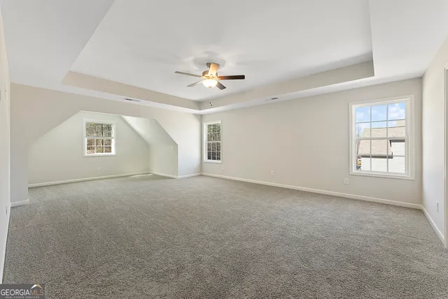 an empty room with windows and ceiling fan