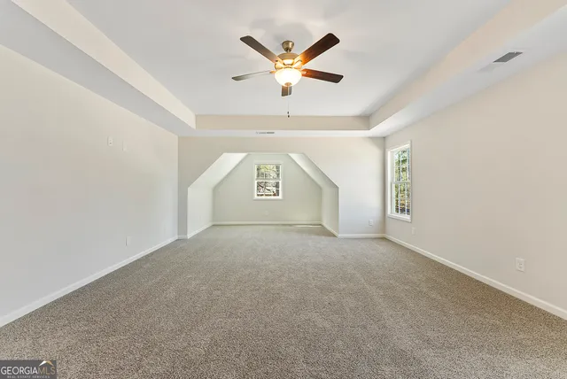 an empty room with window and ceiling fan