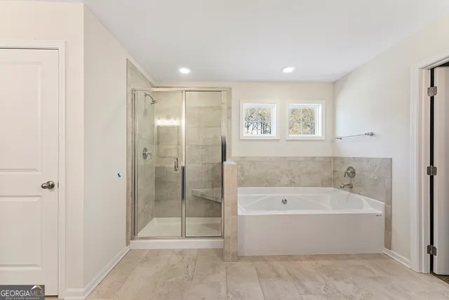 a spacious bathroom with a bathtub and shower