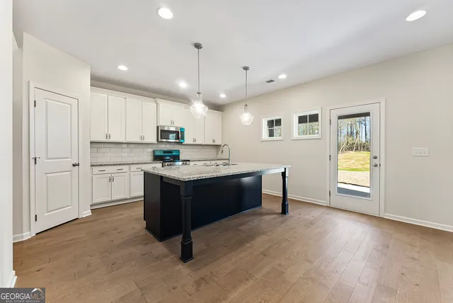 a kitchen with kitchen island granite countertop wooden cabinets and white appliances