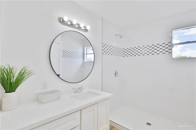 a bathroom with a sink a mirror and a shower