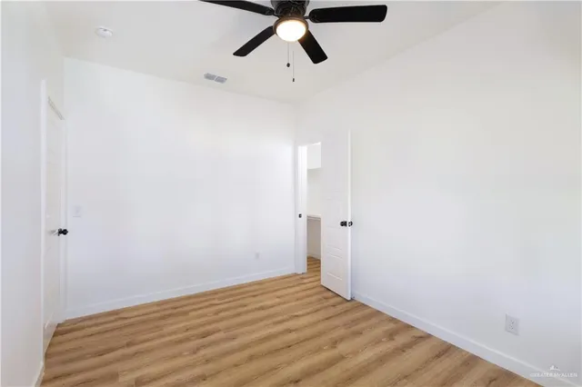 a view of empty room with wooden floor