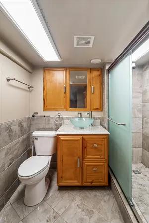 a bathroom with a granite countertop toilet sink and mirror