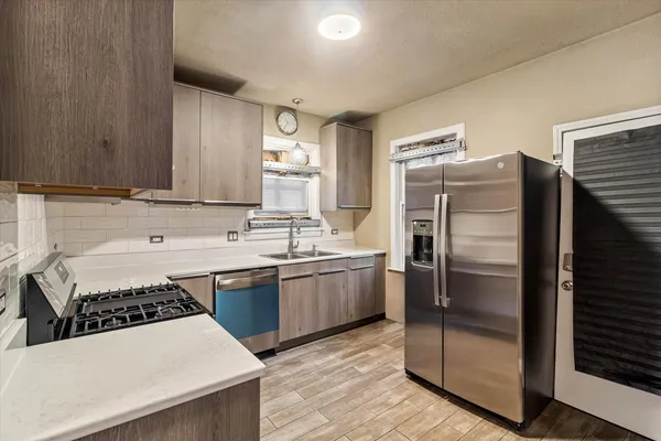 a kitchen with a sink a refrigerator and a stove top oven