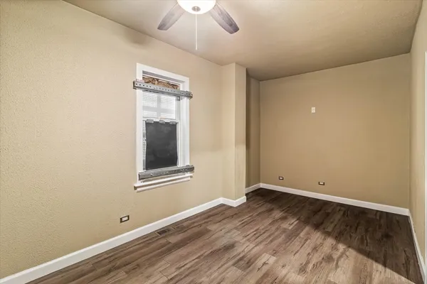 an empty room with a window and wooden floor