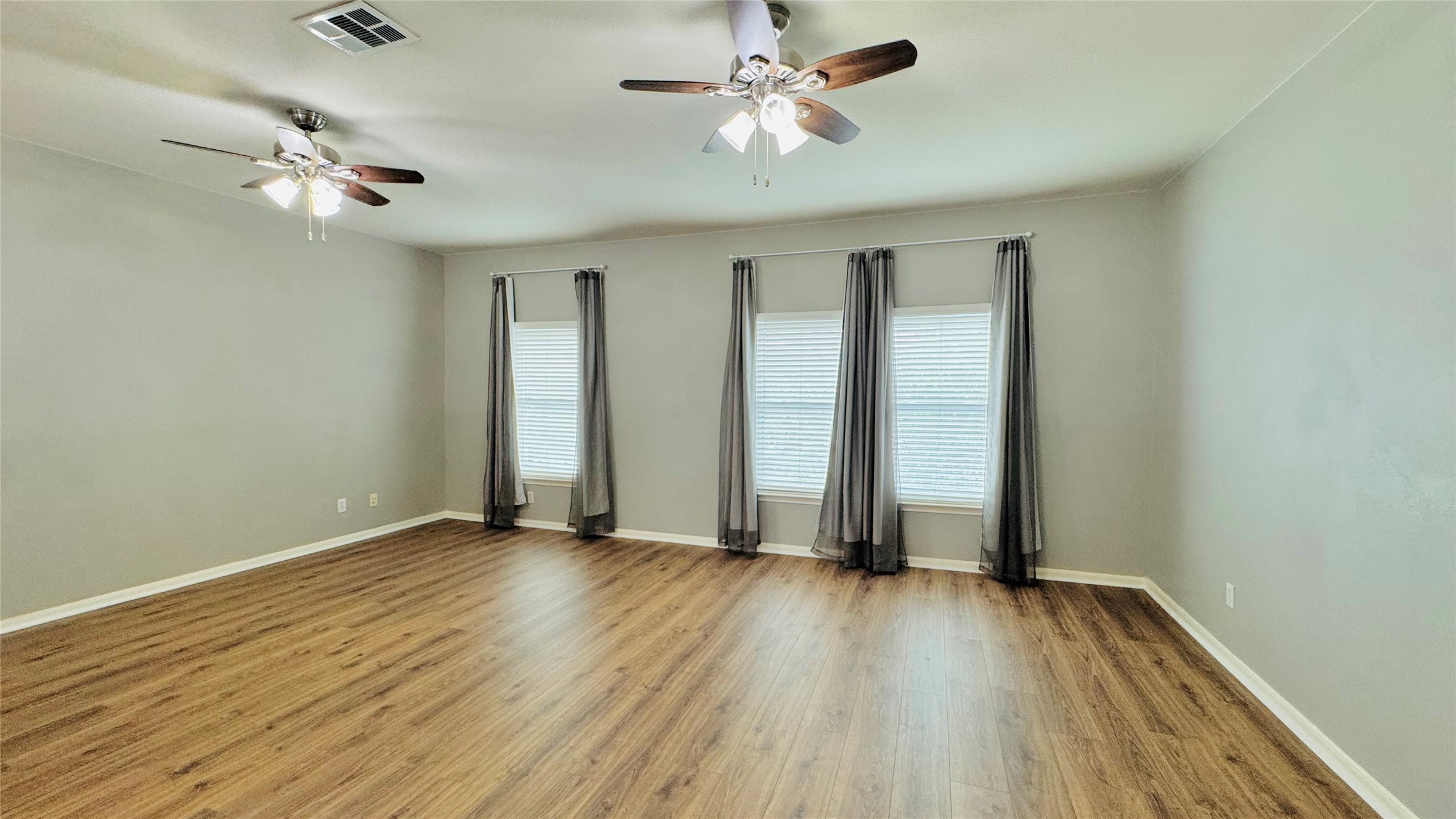 401 Witte Road Kyle, TX 78640 - Photo 14 of 24 Upper living- Well-lit living area with rich wood flooring and multiple windows for abundant light.