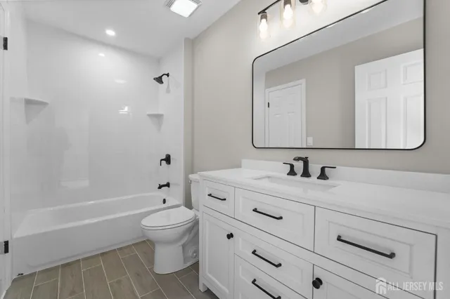 a bathroom with a sink a toilet and a large mirror