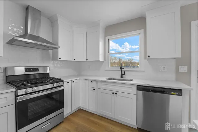 a kitchen with white cabinets appliances and a sink