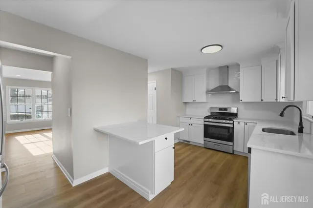 a kitchen with stainless steel appliances a sink stove and cabinets