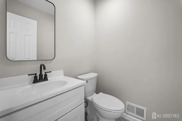 a bathroom with a toilet a sink and mirror