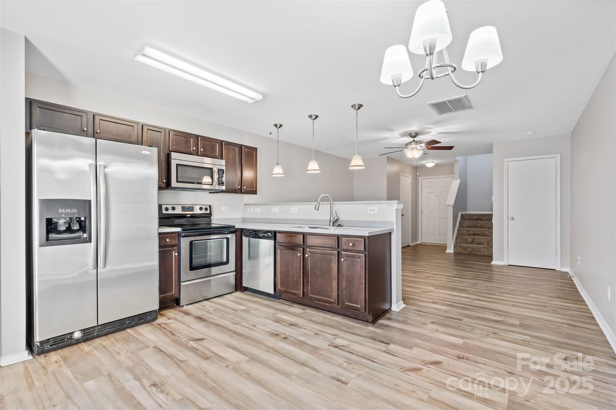 325 River Clay Road Fort Mill, SC 29708 - Photo 4 of 15 a kitchen with a refrigerator chandelier and wooden floor