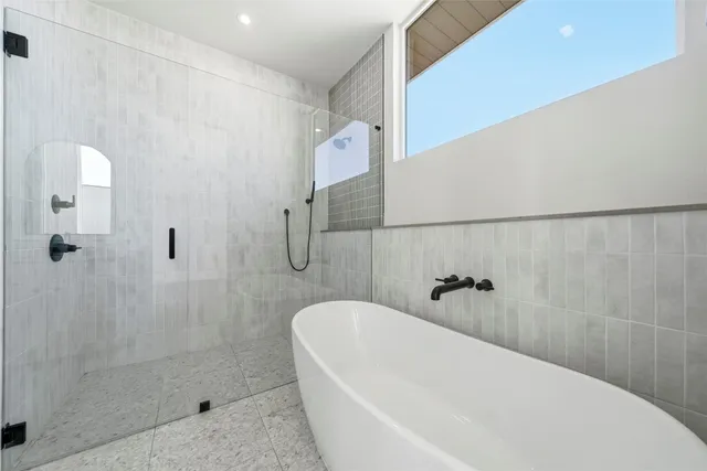 a white bath tub sitting next to a shower