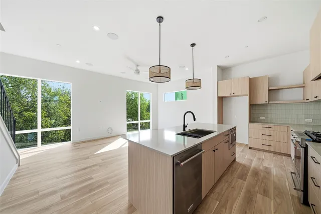 a kitchen with stainless steel appliances granite countertop a sink stove and refrigerator