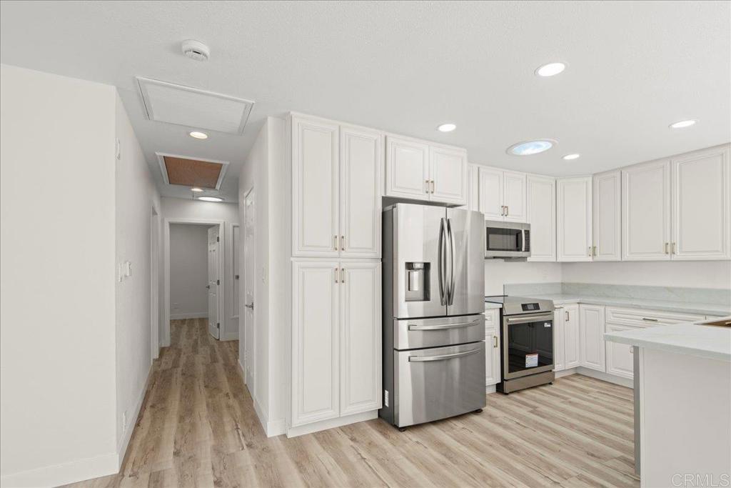 8739 St George Street Spring Valley, CA 91977 - Photo 16 of 30 a kitchen with a refrigerator a oven and white cabinets