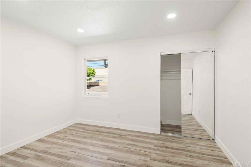8739 St George Street Spring Valley, CA 91977 - Photo 20 of 30 a view of an empty room with wooden floor and a window