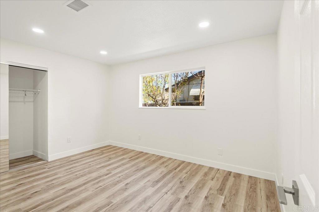 8739 St George Street Spring Valley, CA 91977 - Photo 21 of 30 an empty room with wooden floor and windows