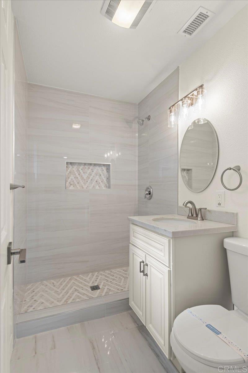 8739 St George Street Spring Valley, CA 91977 - Photo 25 of 30 a bathroom with a toilet a sink and mirror