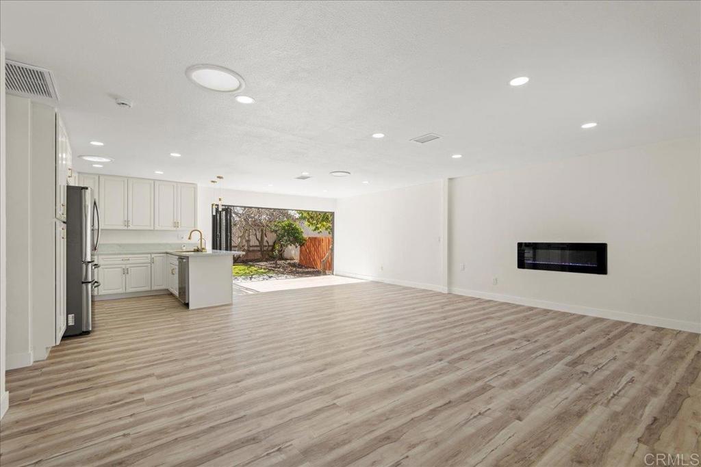 8739 St George Street Spring Valley, CA 91977 - Photo 5 of 30 a view of an empty room with wooden floor and a kitchen