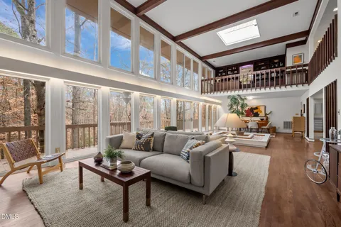 a living room with furniture a rug and a large window