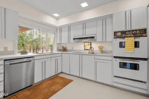 a kitchen with granite countertop white cabinets and white appliances