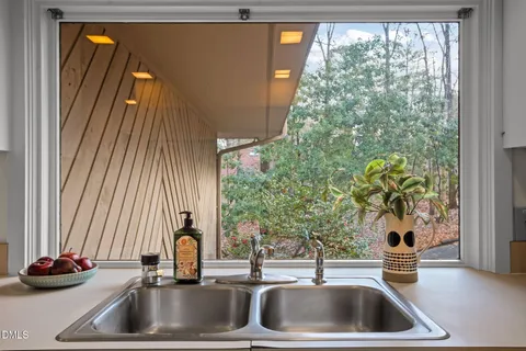 a dining room with furniture and a floor to ceiling window