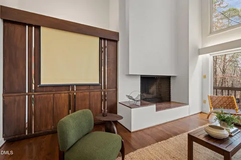 a living room with furniture a flat screen tv and a window