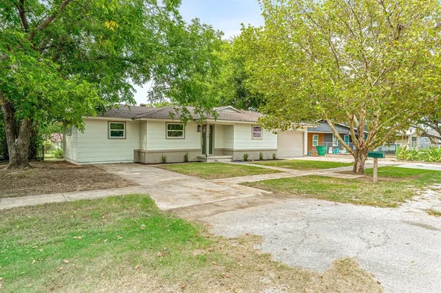 a view of a house with a backyard and a tree