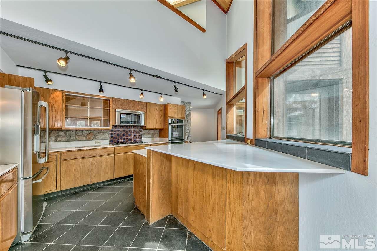 239 Theobald Reno, NV 89521 - Photo 9 of 23 a kitchen with stainless steel appliances granite countertop a sink and cabinets with wooden floor