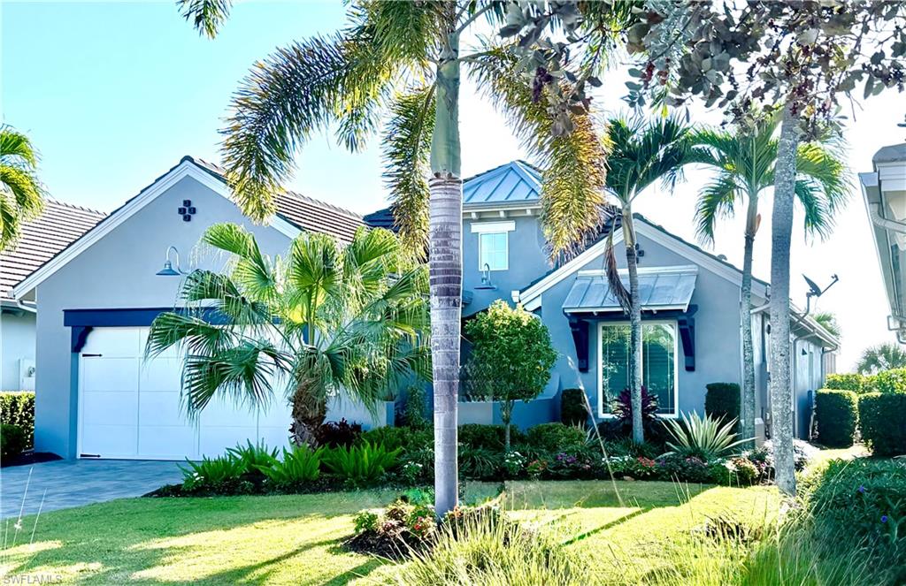 4905 Andros Drive Naples, FL 34113 - Photo 29 of 45 View of front of house with stucco siding, an attached garage, and a front lawn