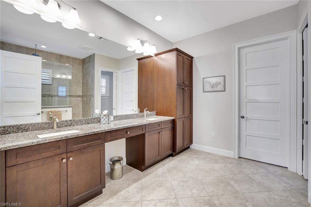 4905 Andros Drive Naples, FL 34113 - Photo 36 of 45 Full bathroom featuring double vanity, walk in shower, and light tile