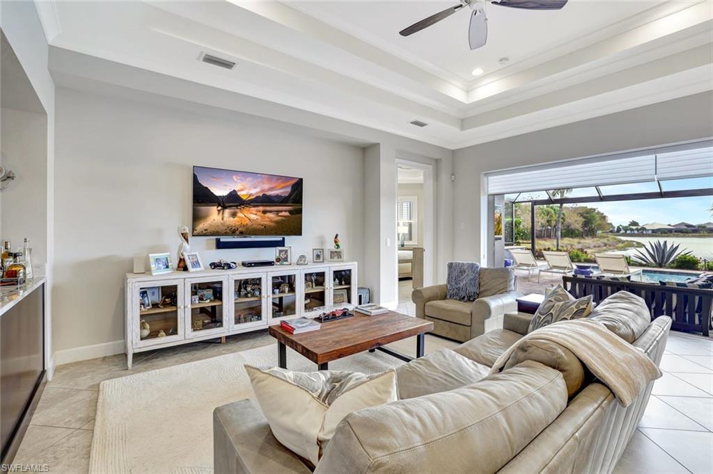 4905 Andros Drive Naples, FL 34113 - Photo 38 of 45 Living area with crown molding, ceiling fan, and a raised ceiling