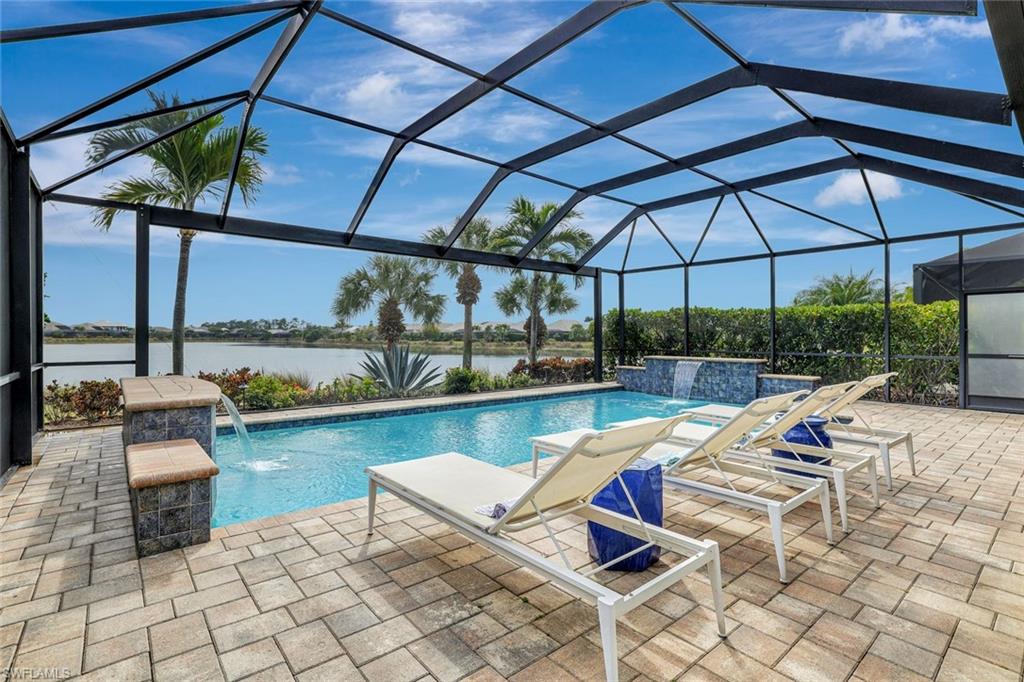 4905 Andros Drive Naples, FL 34113 - Photo 7 of 45 Swimming pool with dual waterfalls, a patio, and a water view
